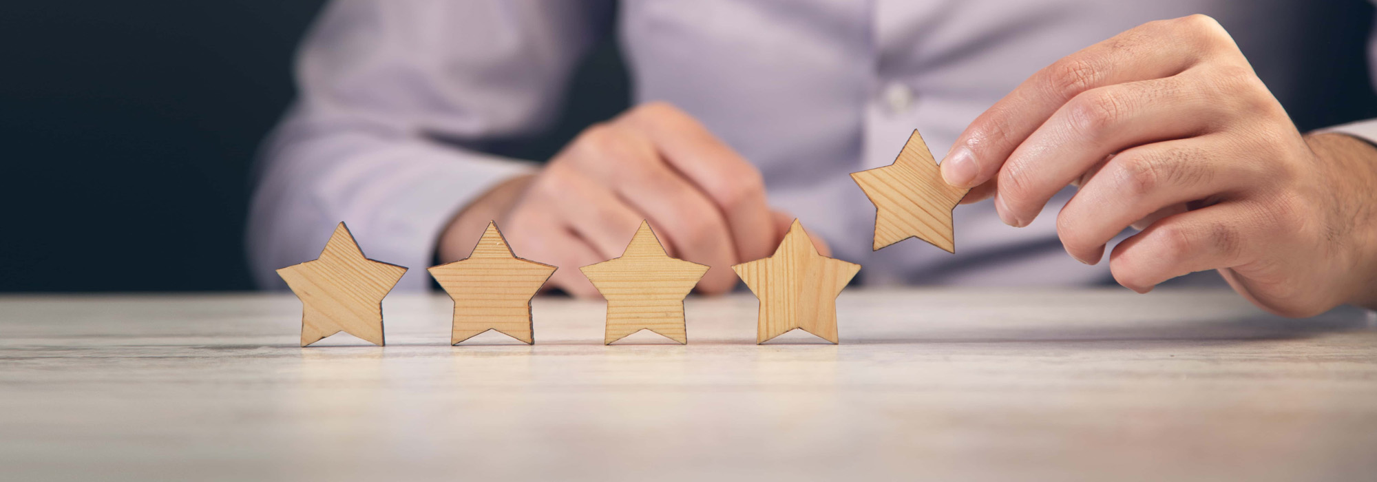 person putting wodden stars on table top