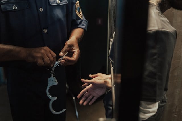 person in jail getting handcuffs removed