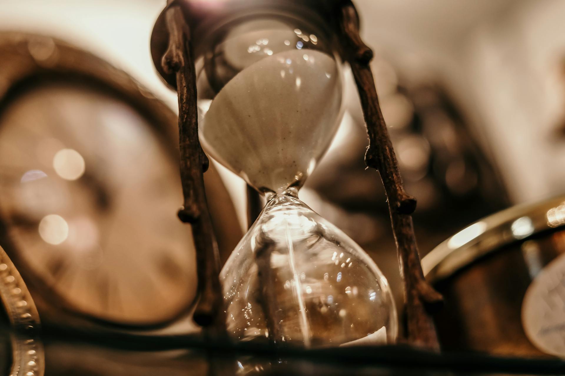 hourglass in front of clocks